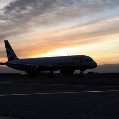 Ett flygplan på marken i solnedgång.
