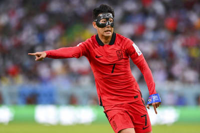 Son Heung-Min spelar fotboll med en ansiktsmask.