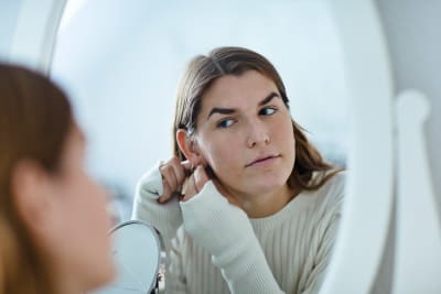 Transkvinna ser sig själv i spegeln