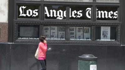 En kvinna promenerar utanför Los Angeles Times byggnad i Los Angeles.