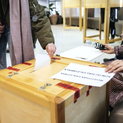 En person lägger sin röst in i valurnan i Berghälls bibliotek i Helsingfors på valdagen den 2 april 2023.