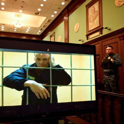 Kuvassa Navalnyi on kaltereiden takana ja katsoo kameraa kohti.