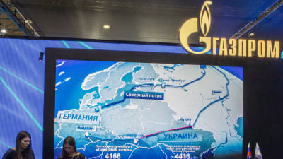 En karta över Ryssland och Europa. Uppe till höger Gazprom-logon och nere till vänster två kvinnor.