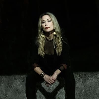 Anna Eriksson istuu mustissa vaatteissa betonilla