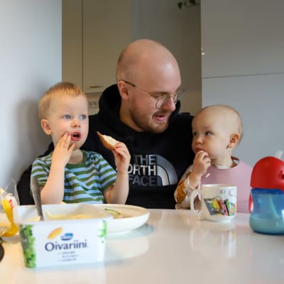 Tonreåbon Atte Tolonen sitter vid matbordet med sina söner och äter bröd.