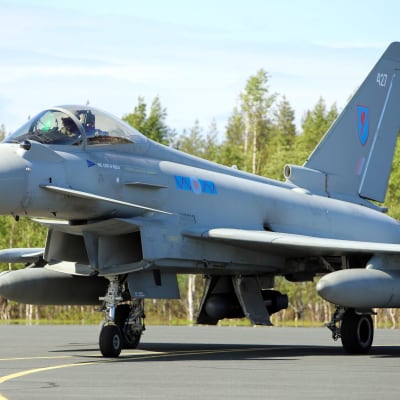 Britannian ilmavoimien Eurofighter Typhoon -hävittäjä rullaa Rovaniemen lentokentällä taustallaan kesäistä koivumetsää.