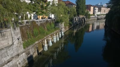 Konst i form av dockor nere längs floden Ljubljanica i Ljubljana, Solovenien.