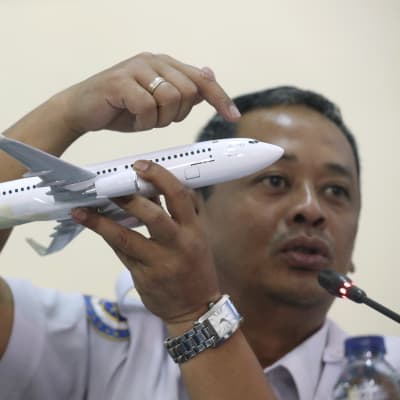 Olycksutredaren Nurcahyo Utomo håller en miniatyr av ett Boeing 737 MAX-plan under en presskonferens om Lion Airs flygolycka.den 28 november.
