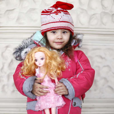 2-vuotias Jasmin rautatieasemalla Barbie-nukkensa kanssa.