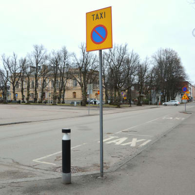 En taxistolpe vid sidan av en gata. 