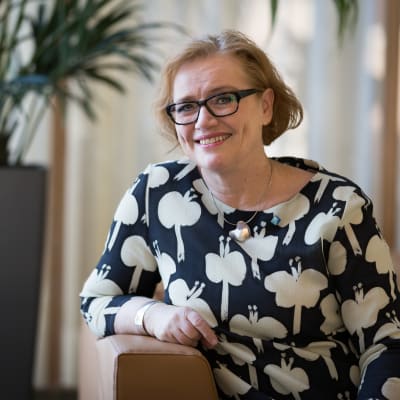 Ritva Viljanen istuu sohvalla.