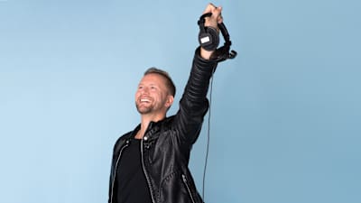 Mikko Silvennoinen kuulokkeet kädessä.