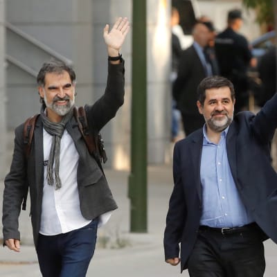 Jordi Cuixart (till vänster) som leder organisationen Omnium och ledaren för ANC, Jordi Sanchez, vinkade utanför Spaniens högsta brottmålsdomstol i Madrid innan de häktades. 