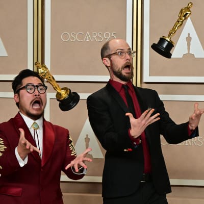 Kaksi miestä jonglööraa Oscar-patsailla.
