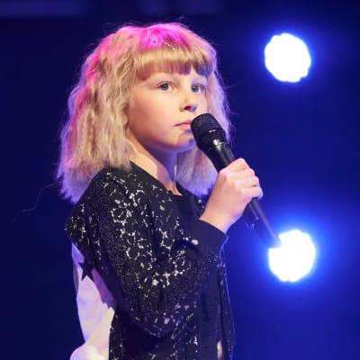 Edith Nyroos under genrepet med blått ljus i bakgrunden.