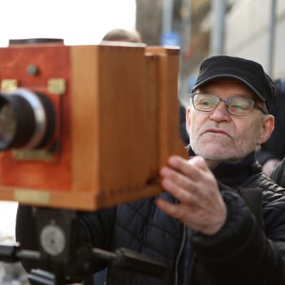 En man tar med en gammal kamera ett nytt fotografi på samma ställe där Finlands första fotografi tog sår 1842.