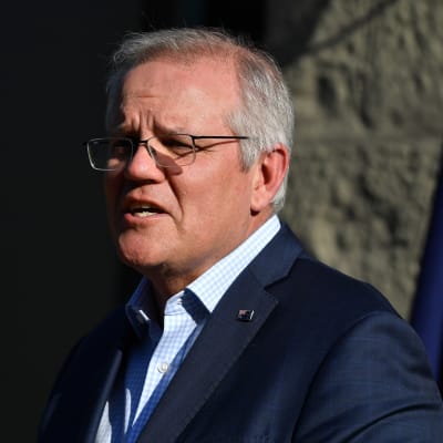 Storbritanniens premiärminister Scott Morrison pratar. Bredvid honom syns Australiens flagga.