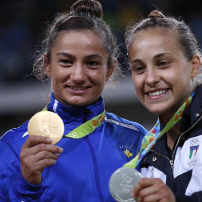 Två judokor poserar med guld- och silvermedaljer från OS.