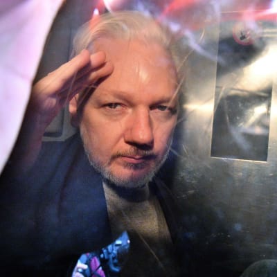 Julian Assange gestikulerar till fotografer då han lämnar domstolen i London den första maj 2019, efter att ha dömts till 50 veckor i fängelse. 