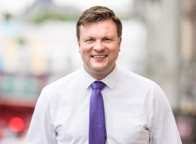 SDP:n Ville Skinnari katsoo kameraan ja hymyilee.