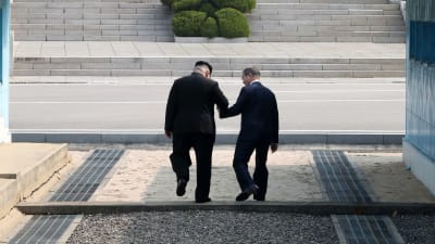 Sydkoreas president Moon Jae-In tar tillsammans med Kim Jong-Un steget tillbaka över stilleståndslinjen in på nordkoreansk mark. 