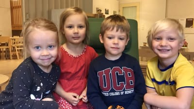Fyra dagisbarn i en länstol.
