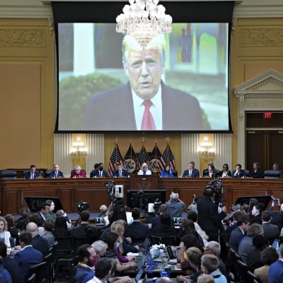 Donald Trumpin kuva heijastuu valkokankaalle kongressin istuntosalissa.