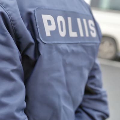 Polis, fotograferad bakifrån så att texten "poliisi" syns på ryggen.