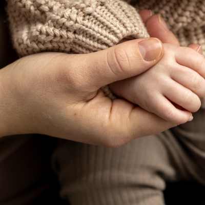 Naisen ja pienen lapsen kädet.