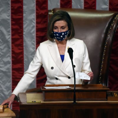 Nancy Pelosi sträcker sig mot klubban för att rösta igenom en lag i USA:s representanthus.