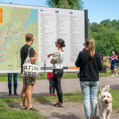 Besökare läser en informationsskylt i Fiskars bruk.