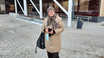 En kvinna står utanför en välfärdscentral i Kyrskslätt.
