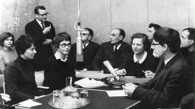 Historisk bild med många mänskor i en radiostudio.