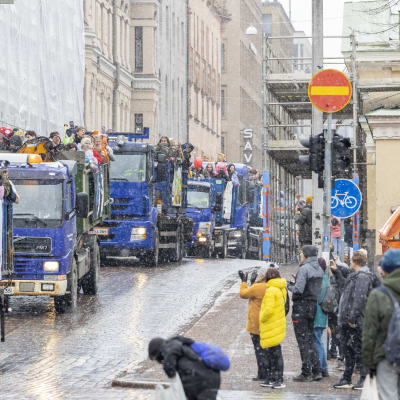 En lång rad med lastbilar fyllda med glada ungdomar.