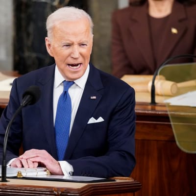 Joe Biden i kavaj i talarstolen, ser förargad ut.