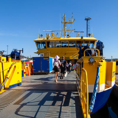 Matkustajia kävelee Yhteysalus Otavan kyytiin Kuusisen satamassa.