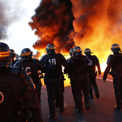 Polisen försöker röja en brinnande barrikad vid ett oljeraffinaderi i Douchy-les-Mines i norra Frankrike.