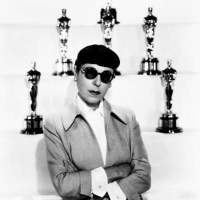 Edith Head står framför sex Oscarsstatyetter.