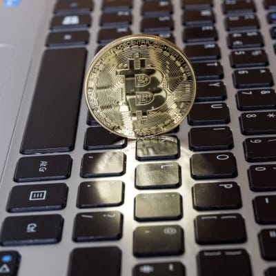 Bitcoin kryptovaluutan symboli tietokoneen näppäimistön päällä.