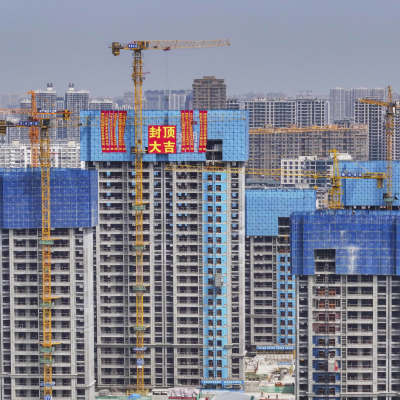 Halvfärdiga flervåningshus och lyftkranar i Kina.