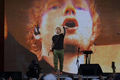 Ed Sheeran på scen med en bild av Ed Sheeran på storskärm bakom honom.