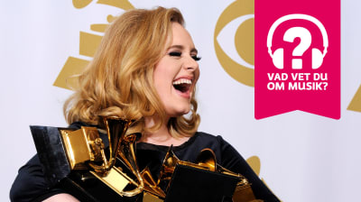 Adele ler stort med öppen mun och har famnen full med Grammystatyetter.