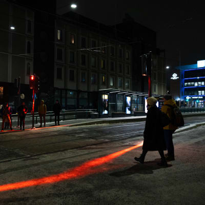 Tampereen raitiotien liikennevalojen punaiset valoheijasteet maassa.