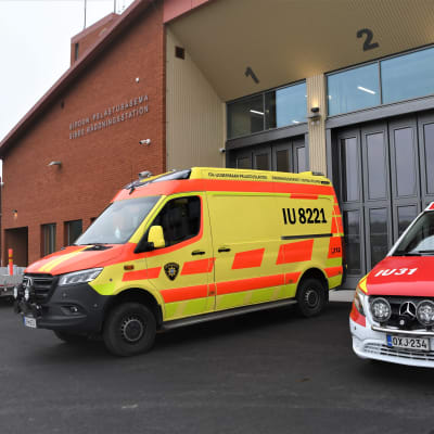 Två ambulanser utanför en nybyggd brandstation.
