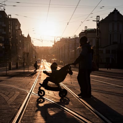 Mies työntää lasta rattaissa Tampereen keskustassa. 