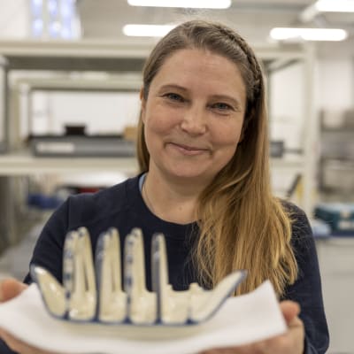 Meriarkeologi Minna Koivikko pitää kädessään hylystä nostettua paahtoleipätelinettä.