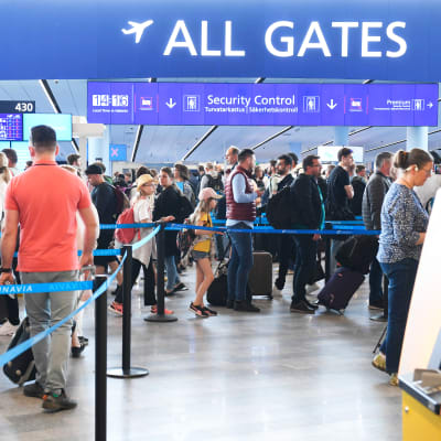 Matkustajat jonottavat lentokentällä turvatarkastukseen. 