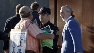 Polisen stoppade en demonstrant som försökte närma sig affärmannen Francisco Correa (till höger) inför en rättegångssession i Madrid den 10 oktober 2016.