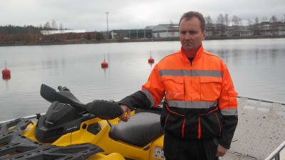 Thomas Grönroos står ombord på sin båt bredvid en fyrhjuling i Daösbruks hamn