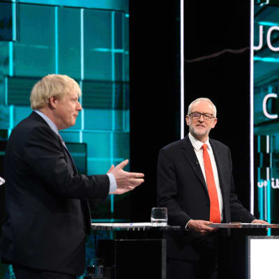 Boris Johnson och Jeremy Corbyn står på en scen vid varsitt bord under en debatt i Tonight's live.